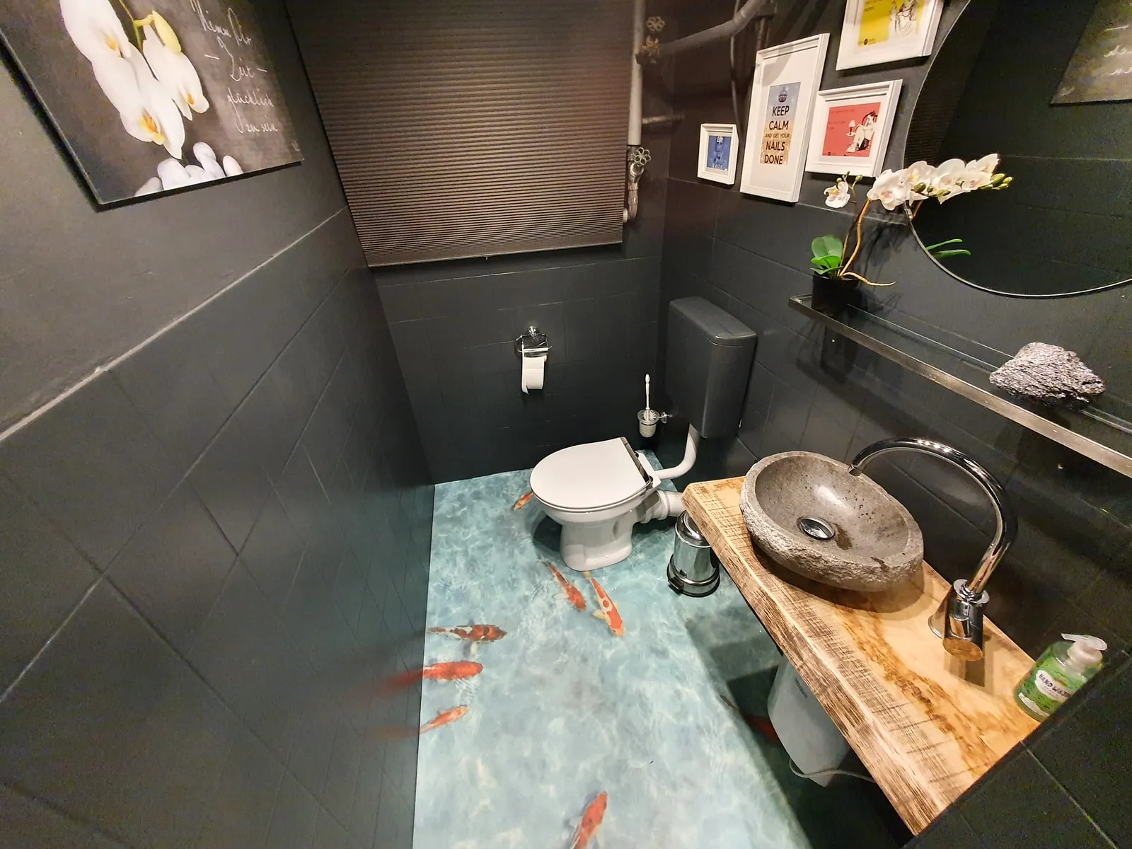 Gäste-WC mit Koi-Motiv im Boden und Steinwaschbecken